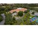 Aerial view of community amenities showcasing a pool, clubhouse, and tennis court surrounded by trees at 11327 Copley Ct, Spring Hill, FL 34609