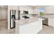 Modern kitchen featuring stainless steel appliances, white cabinets, and a large center island at 1226 Mumford Ct, Zephyrhills, FL 33540