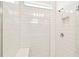 Walk-in shower with white subway tile, glass door, built-in niche, and modern fixtures at 1226 Mumford Ct, Zephyrhills, FL 33540