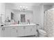 Well-lit bathroom with double vanity, modern fixtures, and a shower with a stylish shower curtain at 125 Island Way # 404, Clearwater Beach, FL 33767