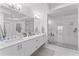 Bright white bathroom with double vanity, quartz countertops, and glass enclosed shower at 125 Island Way # 404, Clearwater Beach, FL 33767