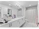 Bright bathroom with double vanity, ample counter space, and a shower with a colorful polka-dot curtain at 125 Island Way # 404, Clearwater Beach, FL 33767