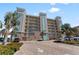 Attractive condo building featuring multiple balconies and lush landscaping in a tropical setting at 125 Island Way # 404, Clearwater Beach, FL 33767