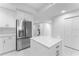 Modern kitchen island with white countertop and stainless steel refrigerator, adjacent hallway visible at 125 Island Way # 404, Clearwater Beach, FL 33767