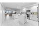 Modern, open-concept white kitchen with stainless steel appliances and an island with seating at 125 Island Way # 404, Clearwater Beach, FL 33767