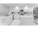 Contemporary white kitchen features an island, stainless steel appliances, and ample counter space at 125 Island Way # 404, Clearwater Beach, FL 33767