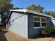 Corner view of the exterior featuring double windows, and grey paint at 12607 Blackberry Row, Hudson, FL 34667