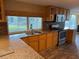 Bright kitchen featuring granite counters, stainless appliances, wood cabinetry, and a window view to the backyard at 12607 Blackberry Row, Hudson, FL 34667