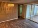 Open-concept living room featuring wood-look tile flooring and sliding glass doors to a screened lanai at 12607 Blackberry Row, Hudson, FL 34667