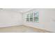 A bright, empty bedroom with light wood-look flooring and a large window at 12614 Glenn Creek Dr, Riverview, FL 33569