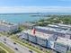 An aerial view of a waterfront condominium complex with scenic views of a bay and city skyline at 131 Bluff View Dr # 409, Belleair Bluffs, FL 33770