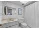 Bathroom featuring floral wallpaper, shower, toilet, and marble countertop at 131 Bluff View Dr # 409, Belleair Bluffs, FL 33770