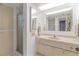 Bright bathroom with a shower, large mirror, and lots of storage at 131 Bluff View Dr # 409, Belleair Bluffs, FL 33770