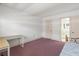 Bedroom with purple carpet, desk, and door to the bathroom at 131 Bluff View Dr # 409, Belleair Bluffs, FL 33770