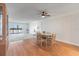 Cozy dining area with wood floors, a ceiling fan, and an adjacent living space with views of the water at 131 Bluff View Dr # 409, Belleair Bluffs, FL 33770