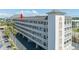 A multi-story condominium building with white balconies, well-maintained landscaping, and convenient covered parking at 131 Bluff View Dr # 409, Belleair Bluffs, FL 33770