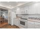 Bright kitchen with white appliances and cabinets, mosaic backsplash, and a view to the dining room at 131 Bluff View Dr # 409, Belleair Bluffs, FL 33770