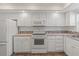 Clean white kitchen featuring essential appliances, ample cabinetry, and a mosaic tile backsplash at 131 Bluff View Dr # 409, Belleair Bluffs, FL 33770