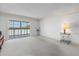 Bright living room with neutral carpet, balcony, and large windows with coverings to let in lots of light at 131 Bluff View Dr # 409, Belleair Bluffs, FL 33770