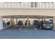 A well-lit covered parking garage with assigned parking spaces under a condominium building at 131 Bluff View Dr # 409, Belleair Bluffs, FL 33770