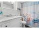 Bathroom featuring white vanity with a marble countertop and nautical themed shower curtain at 14900 Gulf Blvd # 304, Madeira Beach, FL 33708