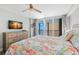 Bright bedroom featuring balcony access, a ceiling fan, and a stylish floral comforter at 14900 Gulf Blvd # 304, Madeira Beach, FL 33708