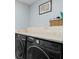 Bright laundry room featuring a front loading washer and dryer, and tile accents at 14900 Gulf Blvd # 304, Madeira Beach, FL 33708