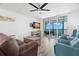 Relax in this cozy living room with a view of the beautiful ocean and balcony access at 14900 Gulf Blvd # 304, Madeira Beach, FL 33708