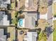 An aerial view of a house with a backyard pool, a driveway, and mature landscaping at 1510 Lakeside Dr, Dunedin, FL 34698