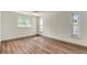 Sunlit bedroom featuring wood floors, ceiling fan, and double-hung windows with white trim at 1510 Lakeside Dr, Dunedin, FL 34698