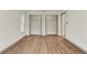 Bedroom features wood floor, closet, and view to ensuite bathroom at 1510 Lakeside Dr, Dunedin, FL 34698