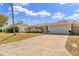 Well-maintained single-story home with a long decorative driveway and attached garage at 1510 Lakeside Dr, Dunedin, FL 34698