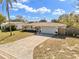 Well-maintained single-story home with a long decorative driveway at 1510 Lakeside Dr, Dunedin, FL 34698