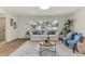 Bright living room with a large window, white sofa, and stylish decor with light-tone wood flooring at 1510 Lakeside Dr, Dunedin, FL 34698