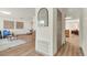 Hallway and entryway showcasing hardwood floors, arched mirror, and neutral paint at 1510 Lakeside Dr, Dunedin, FL 34698