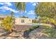 Backyard features pool, wooden deck, lush tropical landscaping, and sunny sky at 1510 Lakeside Dr, Dunedin, FL 34698