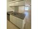 Kitchen with tiled floor and stainless steel sink overlooking a well-lit living area at 16415 Enclave Village Drive # 108, Tampa, FL 33647