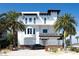 Stunning Mediterranean home with a sleek car, beautiful balconies, lush landscaping, and a secure fence at 20256 Gulf Blvd, Indian Shores, FL 33785