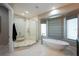 Elegant main bathroom with a soaking tub under a large window and a spacious glass-enclosed shower at 20256 Gulf Blvd, Indian Shores, FL 33785