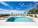 Beautiful pool and jacuzzi with lounge chairs, greenery, and an ocean view in the background at 20256 Gulf Blvd, Indian Shores, FL 33785
