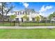 Charming two-story home with a manicured front yard, iron fence and lush palm trees at 2301 S Church Ave, Tampa, FL 33629