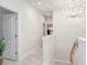 Upstairs hallway with neutral paint, modern chandelier, white trim, and light wood flooring at 2301 S Church Ave, Tampa, FL 33629