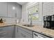 Close up on kitchen sink and countertop, with gray cabinets, stainless steel appliances, and white backsplash at 2608 2Nd N Ave, St Petersburg, FL 33713