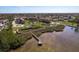 Waterfront property featuring pier, pond, boardwalk, and landscaping at 351 Windrush Loop, Tarpon Springs, FL 34689