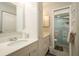 Bright bathroom features double sinks, white cabinets, and a glass-enclosed shower at 351 Windrush Loop, Tarpon Springs, FL 34689