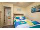 Bright bedroom with ensuite bathroom features a colorful quilt and seaside decor at 351 Windrush Loop, Tarpon Springs, FL 34689