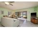 Cozy living room with tile flooring, ceiling fan, comfortable seating, and access to the screened porch at 351 Windrush Loop, Tarpon Springs, FL 34689