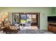 Bright living room with large sliding doors to the screened in porch, fan, and comfortable seating at 351 Windrush Loop, Tarpon Springs, FL 34689