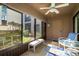 The screened in porch has an outdoor ceiling fan, a door leading to the outside, and a view of the grassy lawn at 351 Windrush Loop, Tarpon Springs, FL 34689