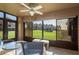 The screened in porch has an outdoor ceiling fan and a beautiful view of the grassy lawn at 351 Windrush Loop, Tarpon Springs, FL 34689
